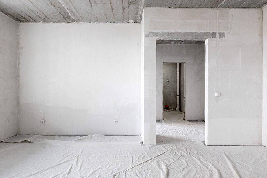Una habitación vacía con paredes blancas y una puerta.