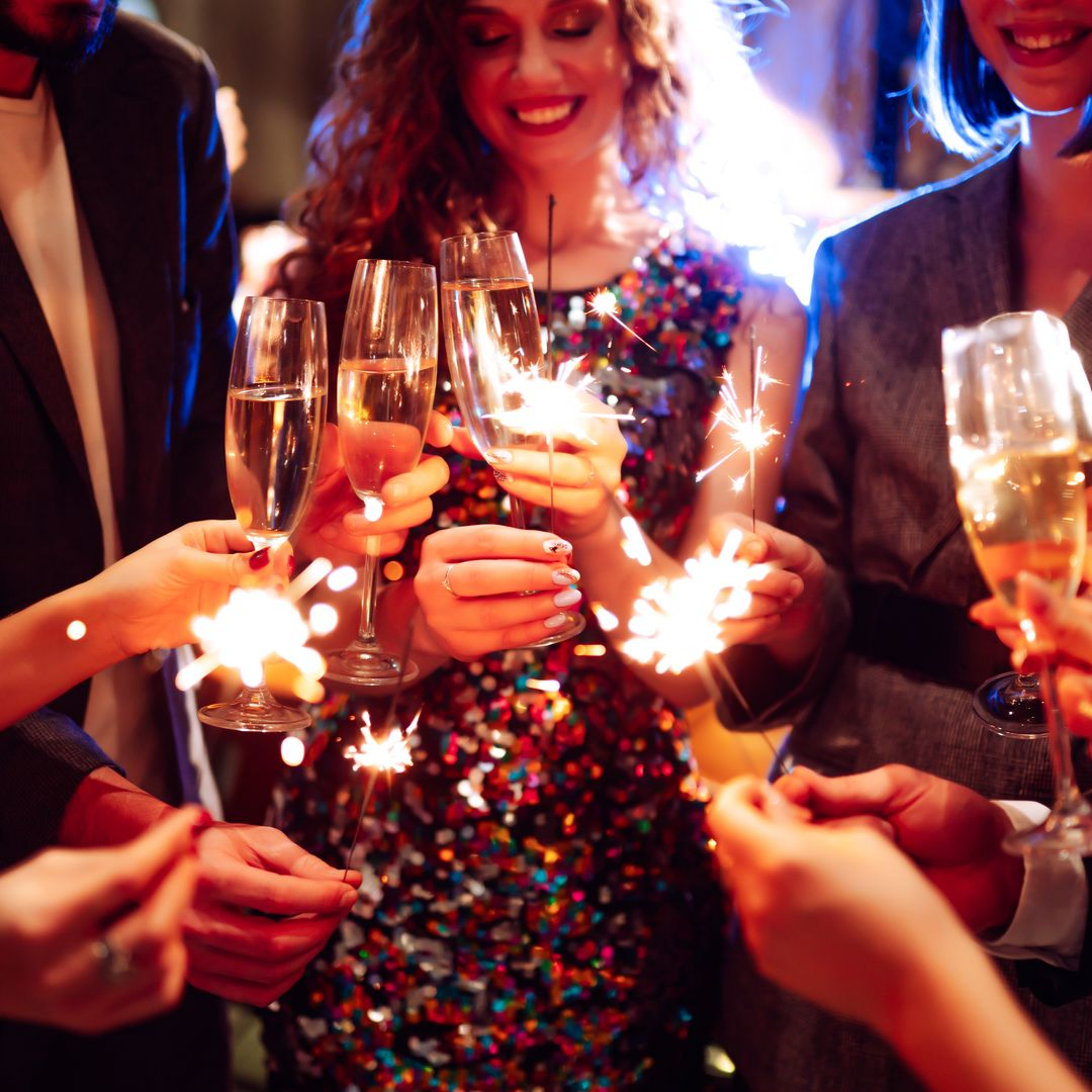 Des gens trinquent avec du champagne et des feux d'artifice.