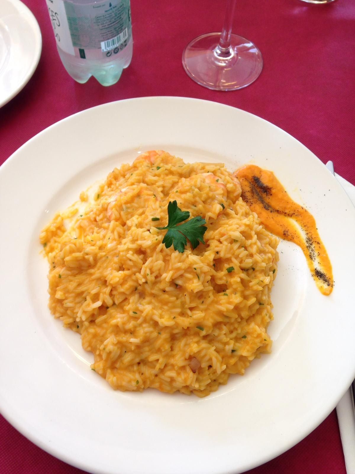 Un plato de comida con una botella de agua al fondo.