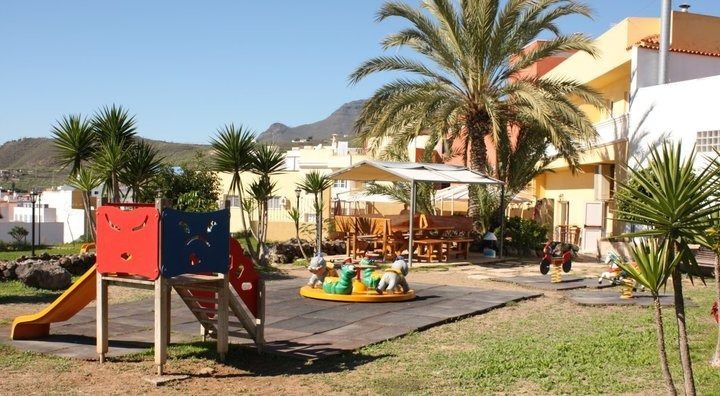 Un parque infantil con un tiovivo y un tobogán