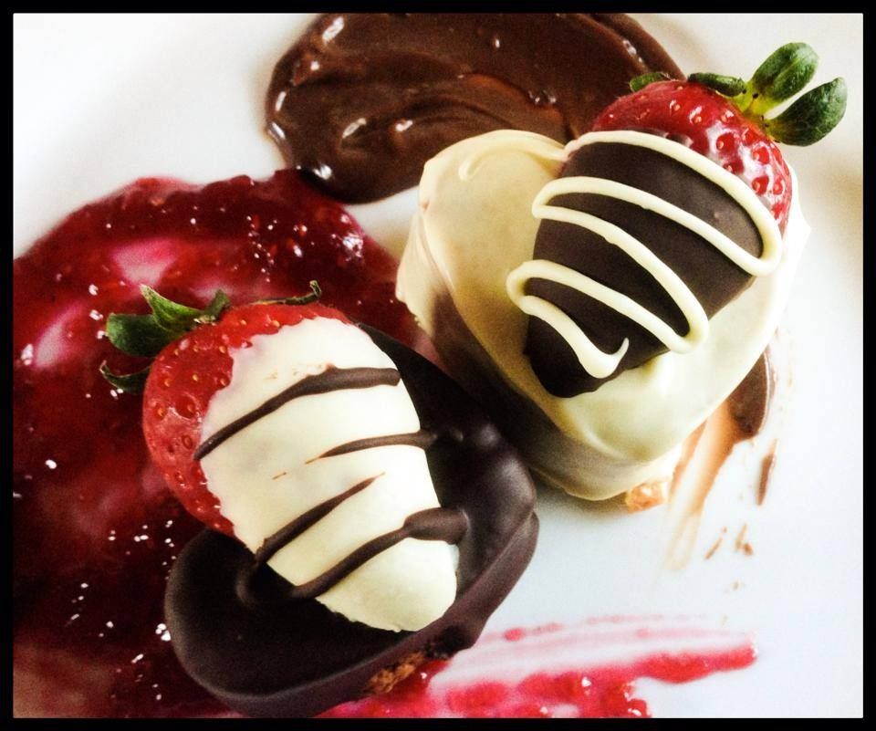 Un plato blanco cubierto con fresas cubiertas de chocolate.