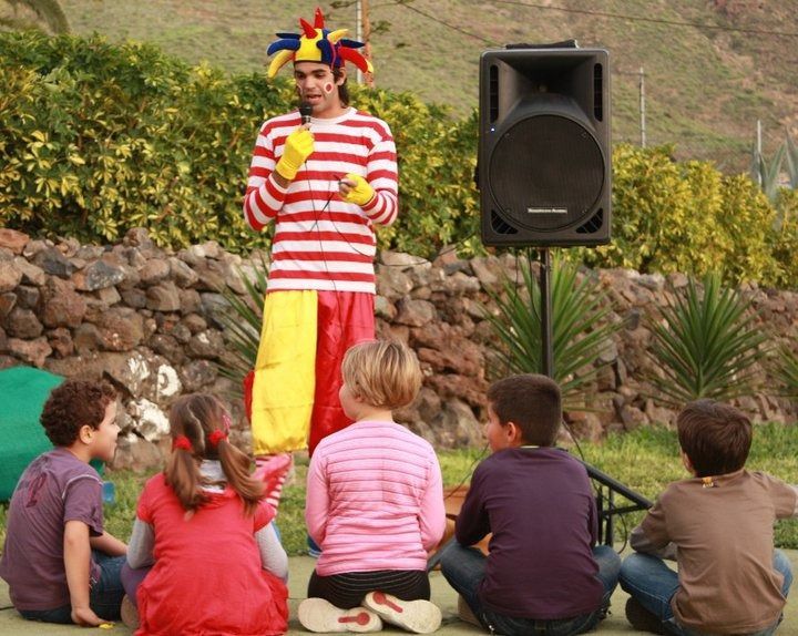 Un grupo de niños está viendo actuar a un payaso.