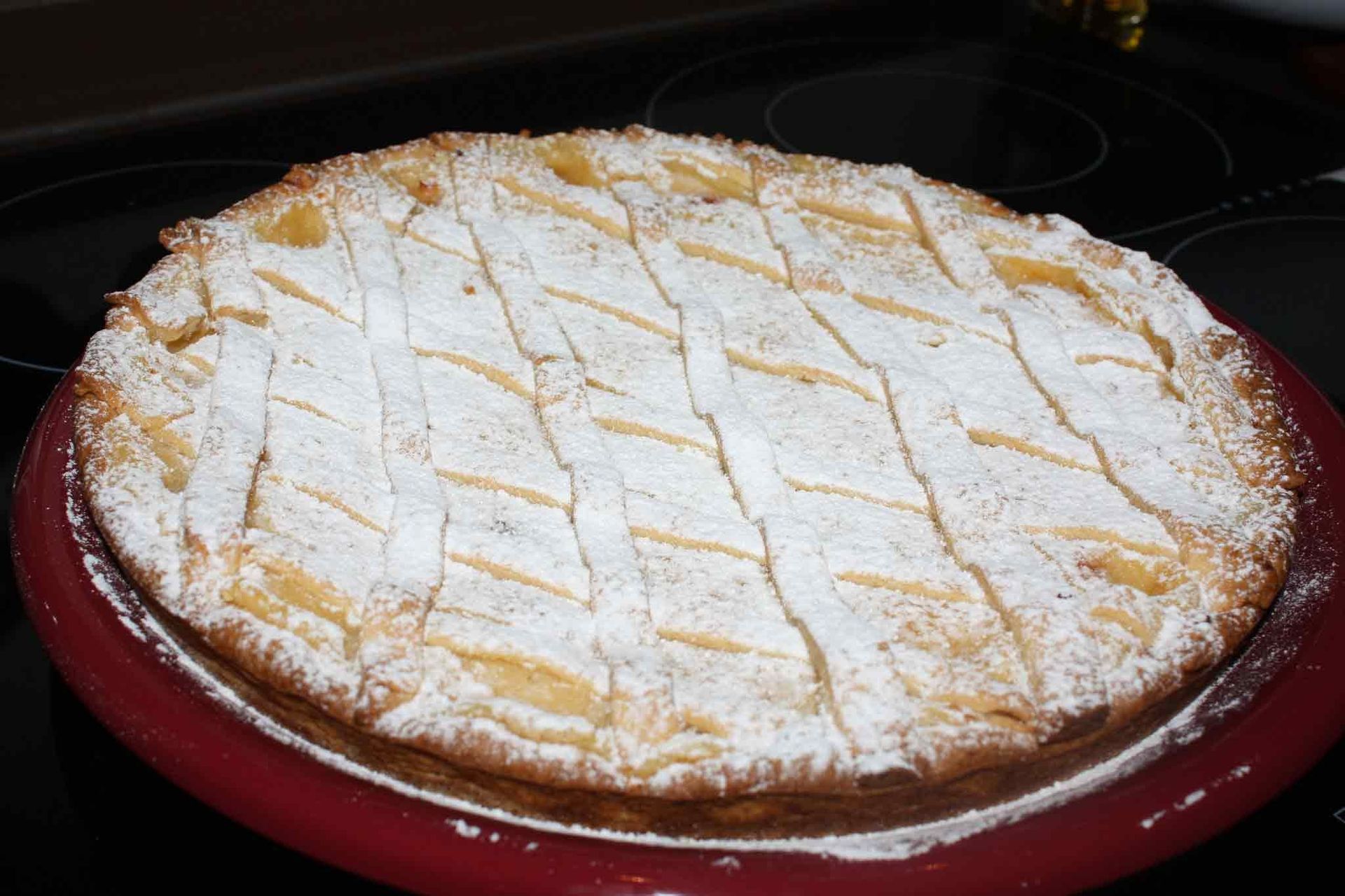 Un pastel con azúcar glas encima está en un plato rojo.