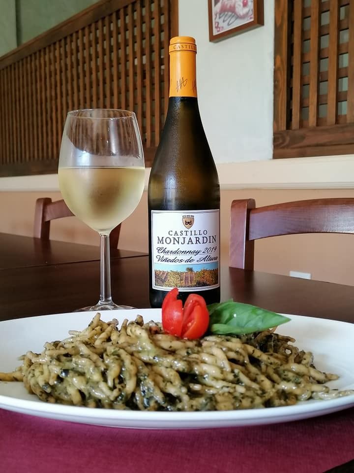 Una botella de vino Monjardin se encuentra junto a un plato de pasta.