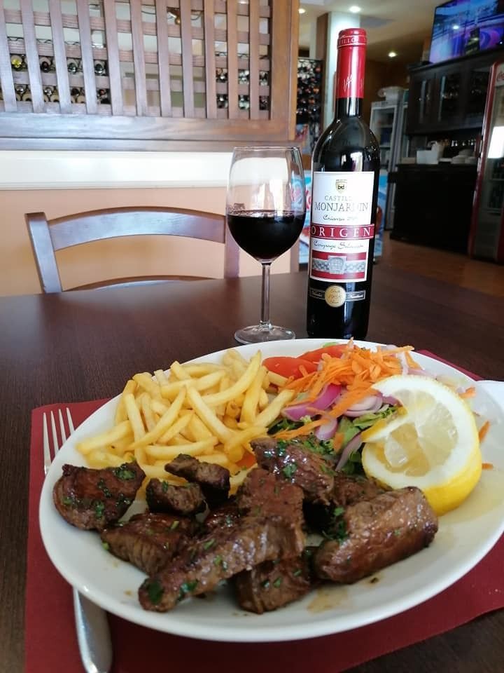 Una botella de vino se encuentra junto a un plato de comida.
