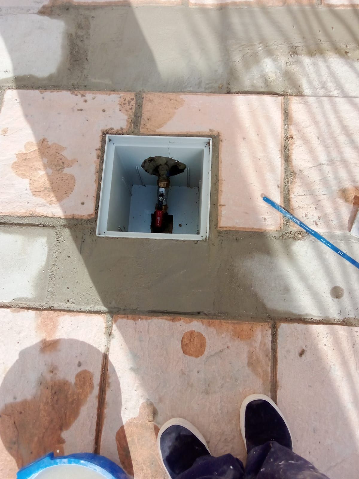 Una persona está parada junto a una caja en el suelo.