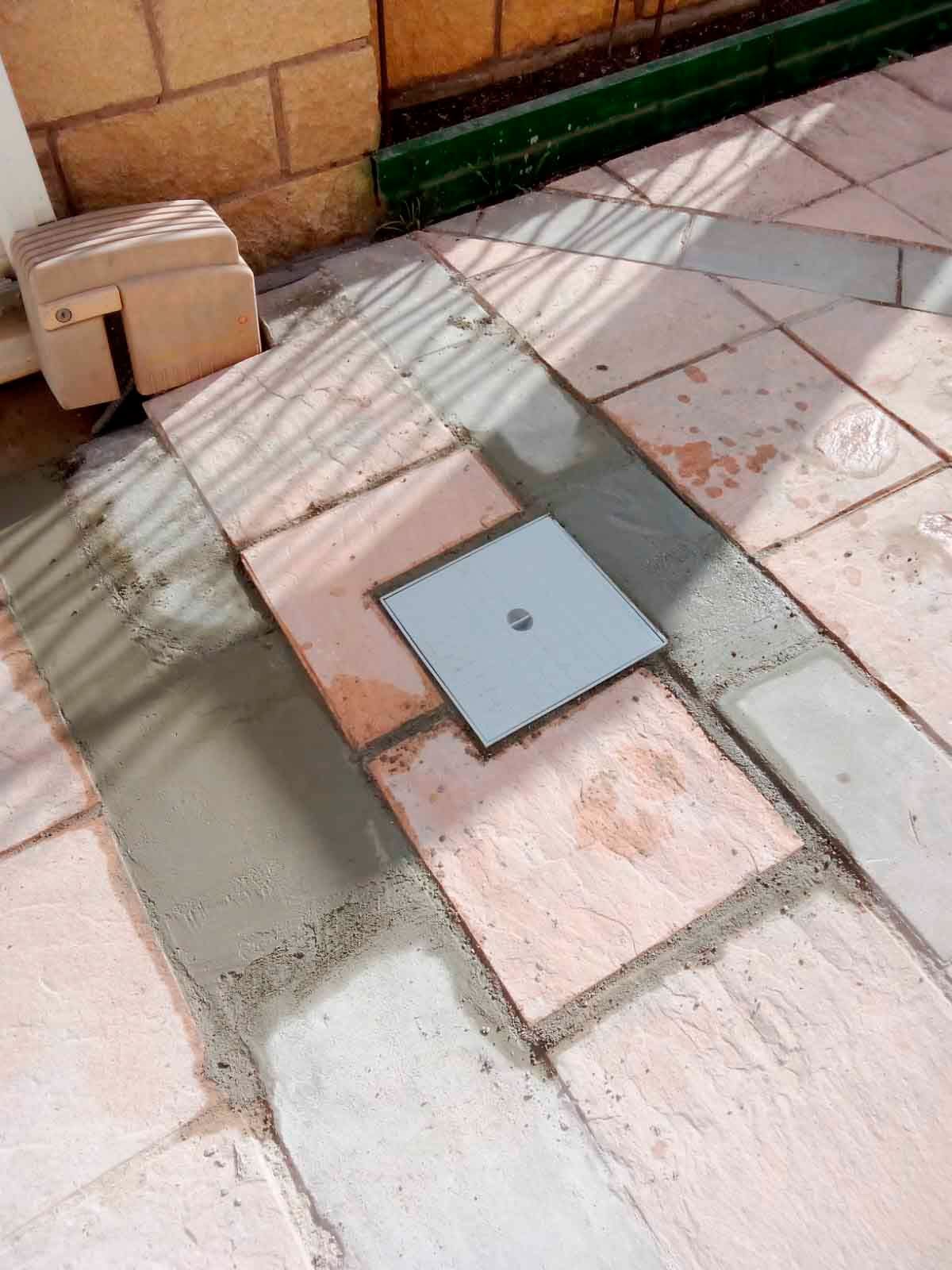 Una pasarela de ladrillos con un agujero cuadrado en el medio.