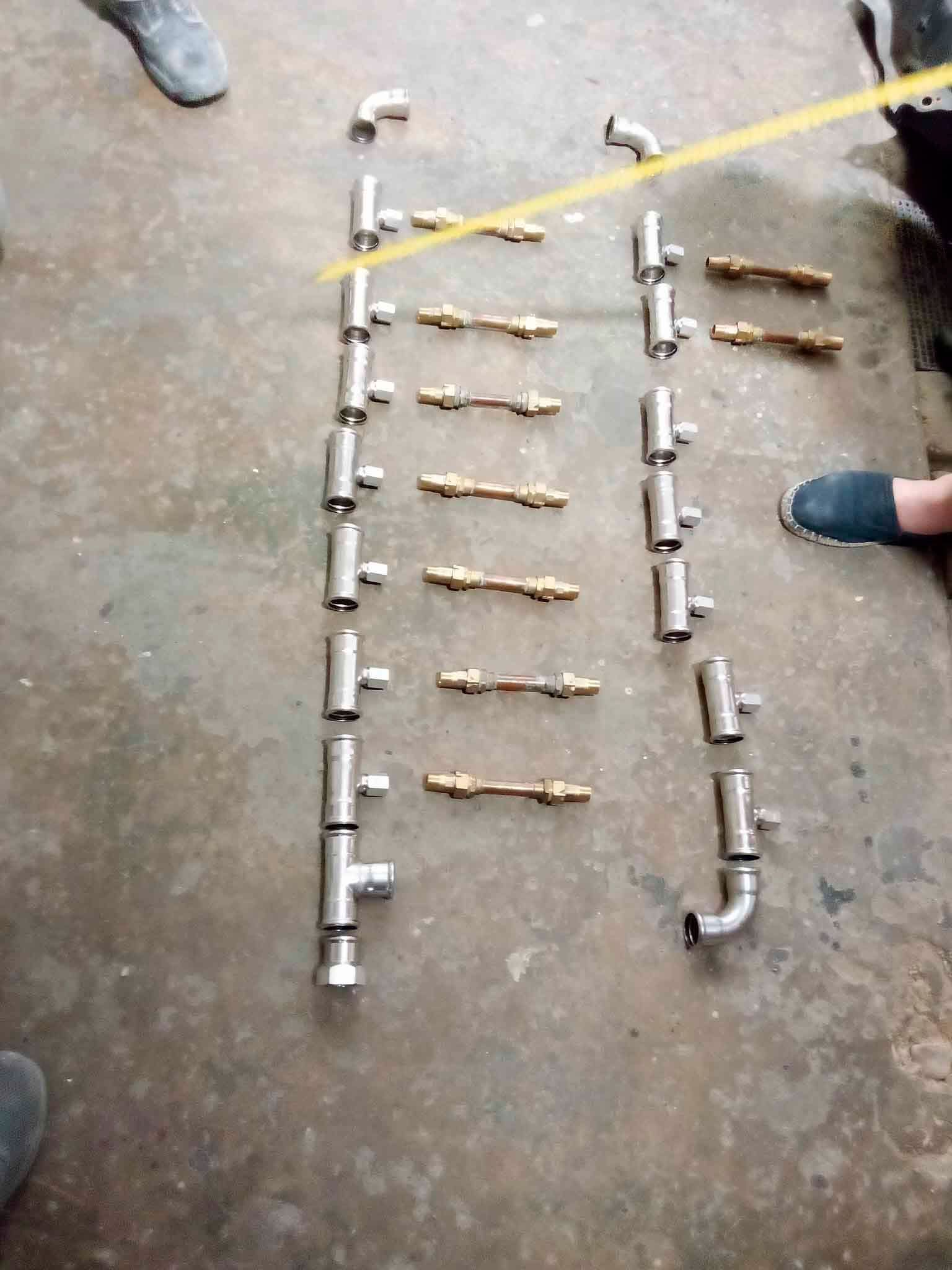 Una persona está parada junto a una fila de tubos de metal en el suelo.