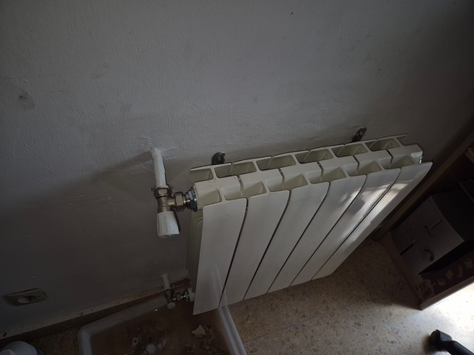 Un radiador blanco está colgado en la pared de una habitación.