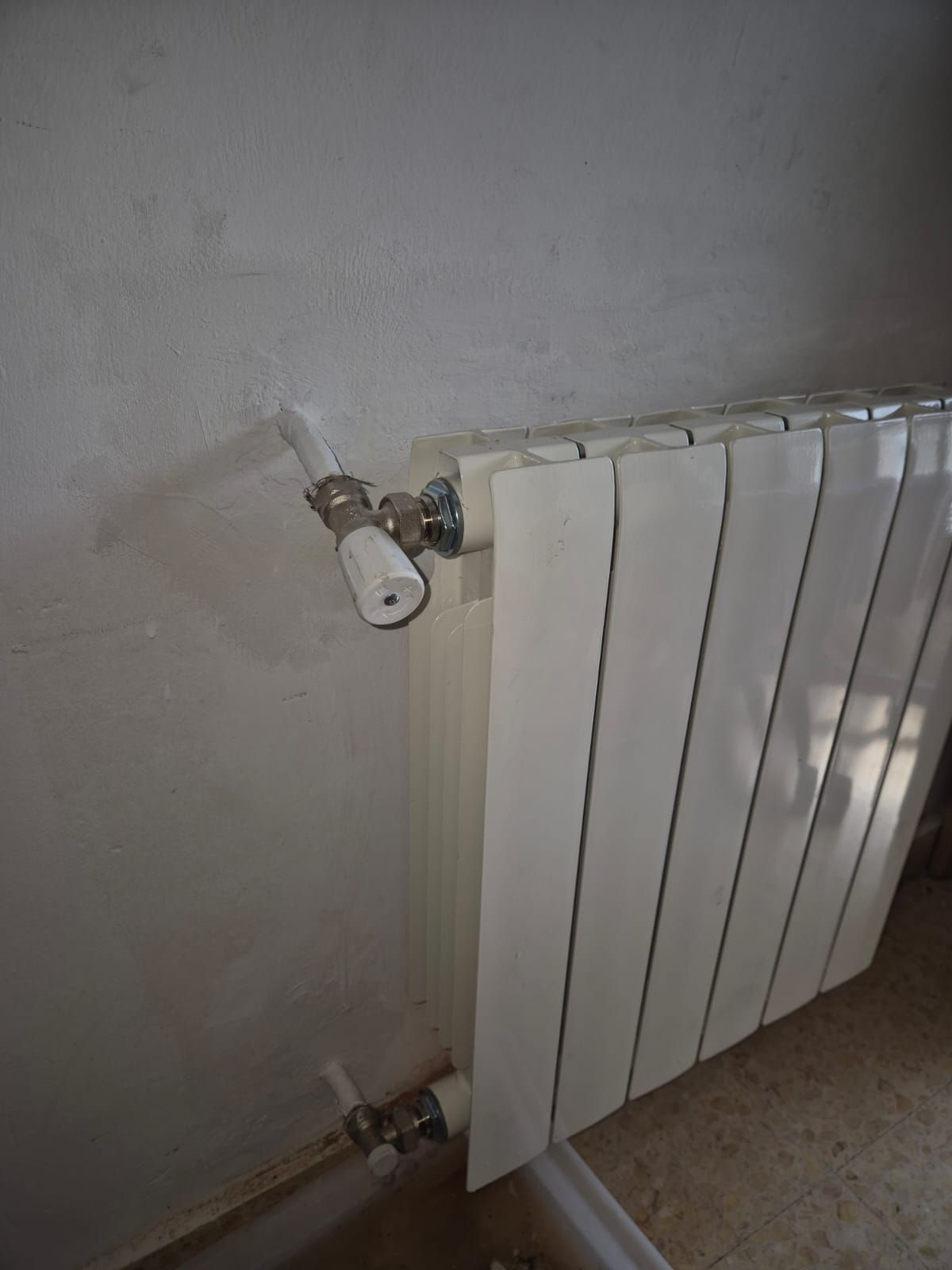 Un radiador blanco está montado en la pared de una habitación.