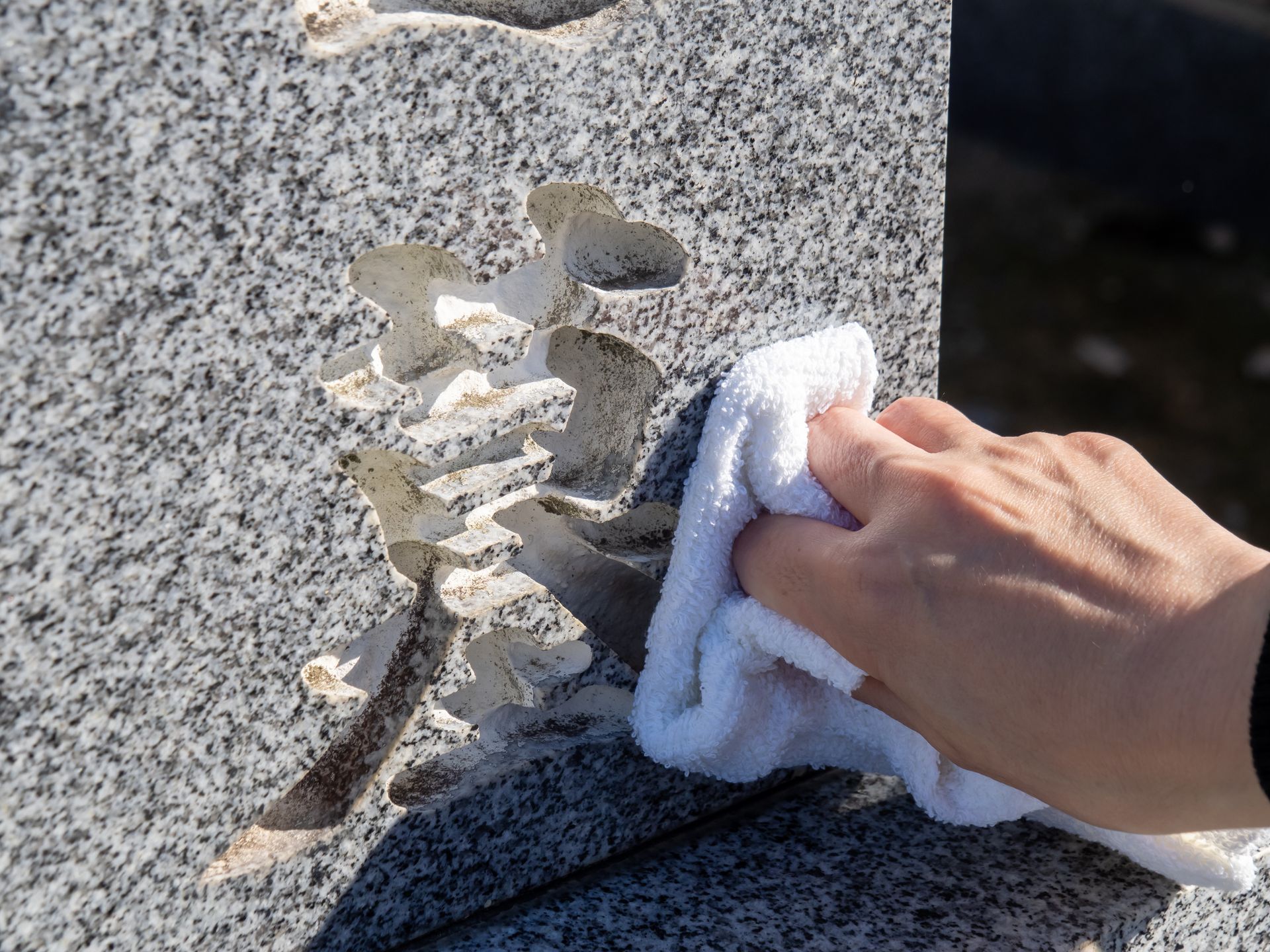 Essuyer à la main une surface en granit ébréchée avec un chiffon blanc.