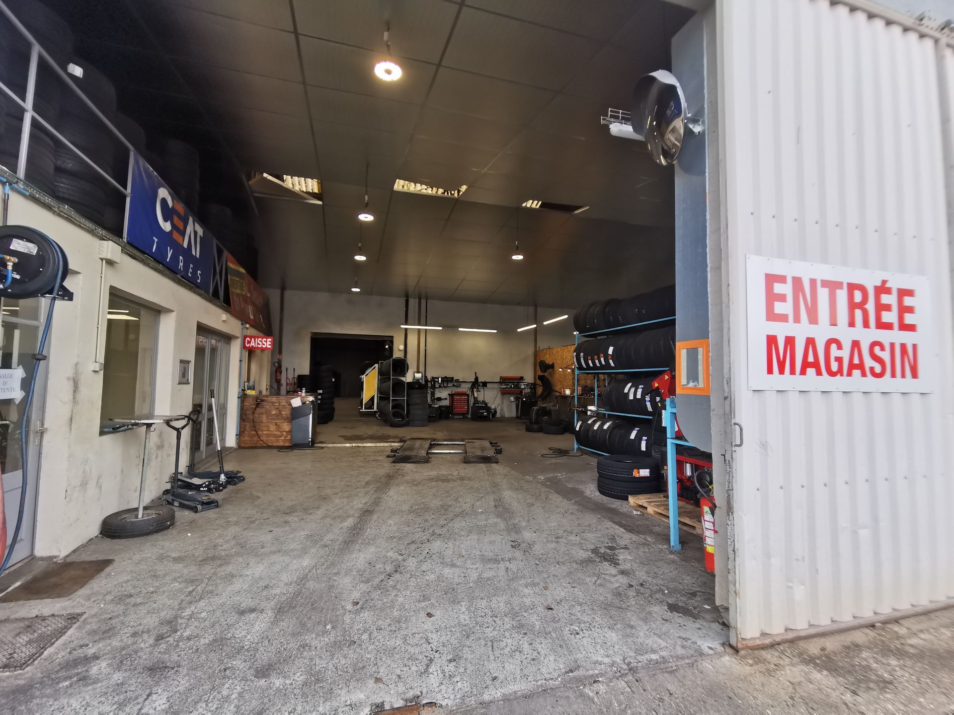 L'entrée du hangar du Central du Pneu d'Occasion avec la caisse à gauche.