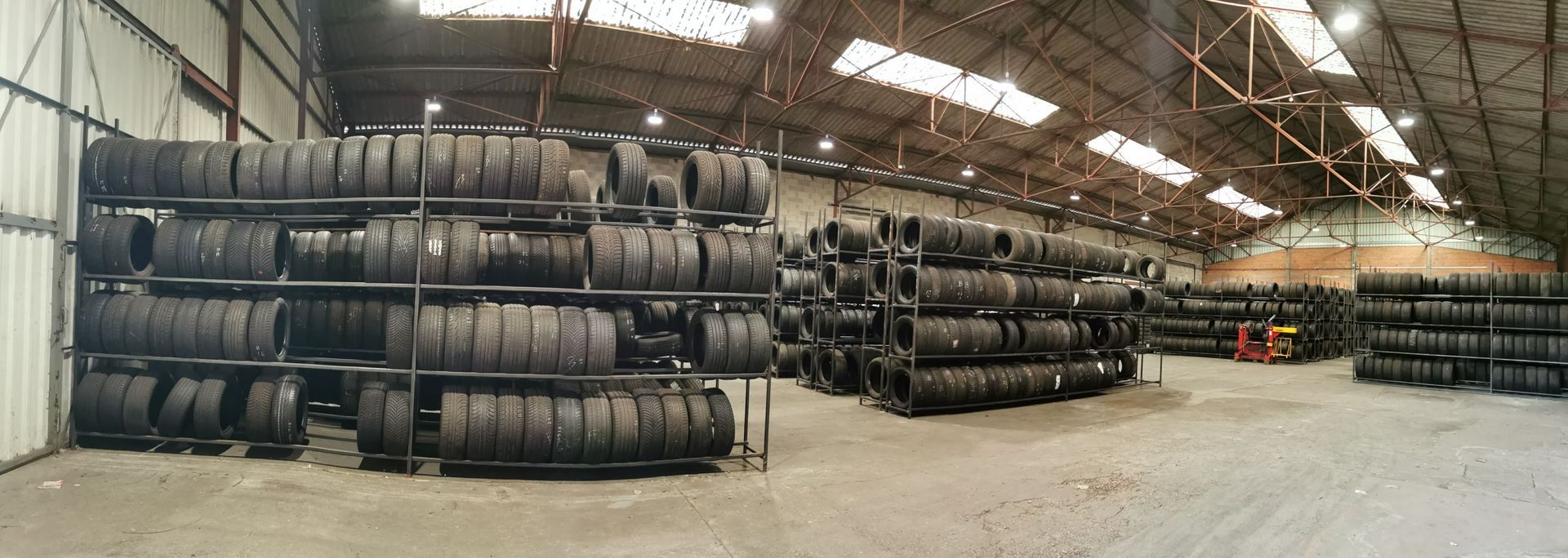 De nombreux pneus sur des étagères dans un hangar.