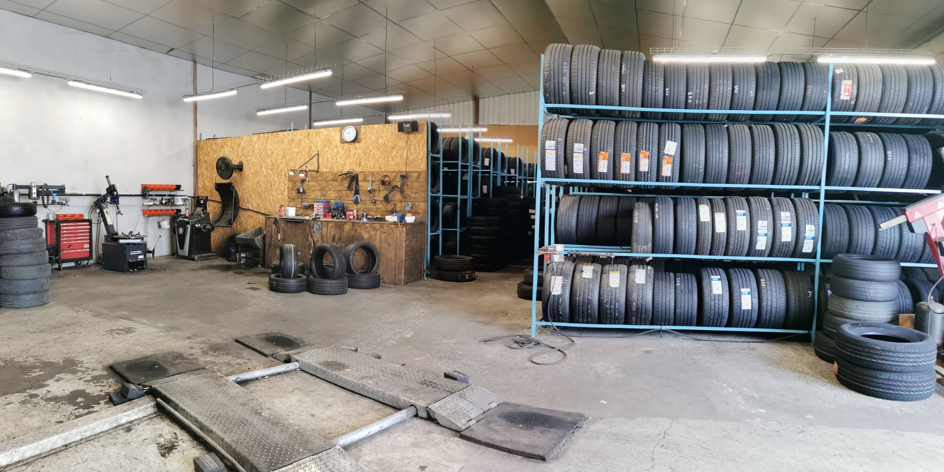De nombreux pneus avec un atelier à gauche.