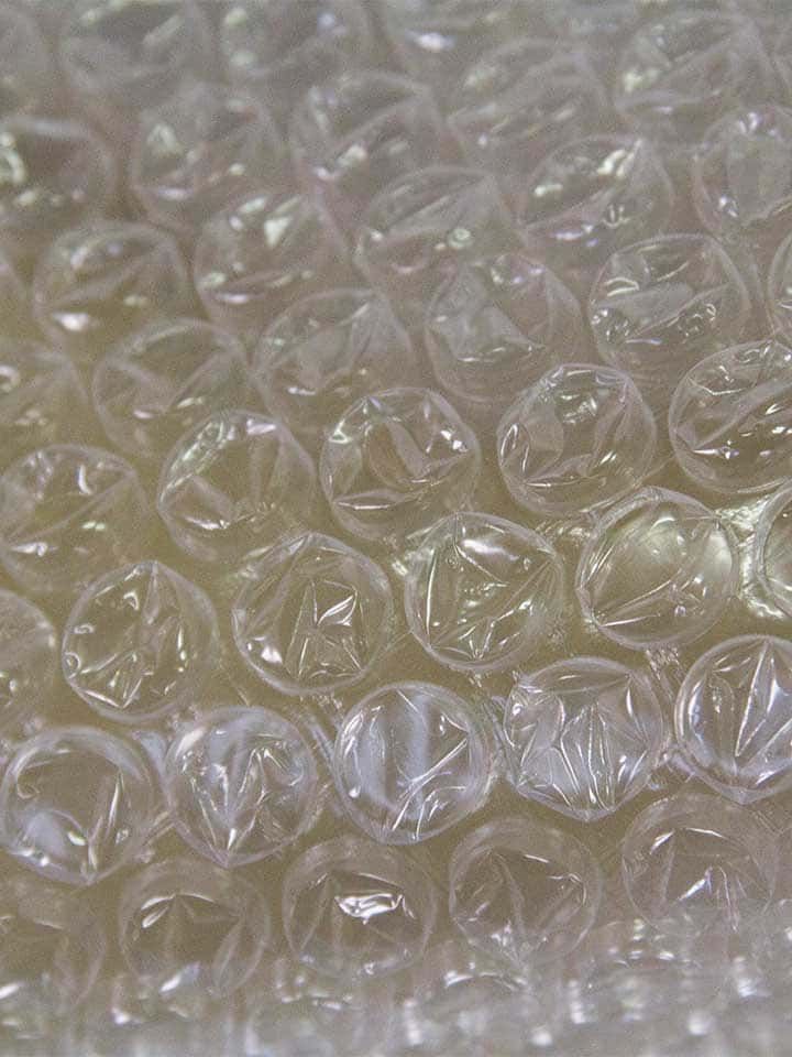 Gros plan sur du film à bulles transparent rempli de bulles d'air pour amortir et protéger.