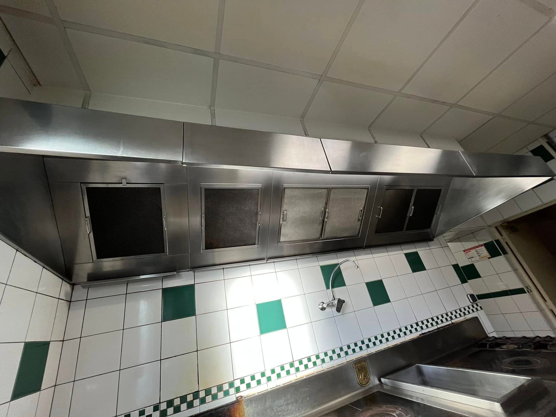 Une hotte aspirante professionnelle en acier inoxydable avec filtres à graisse.