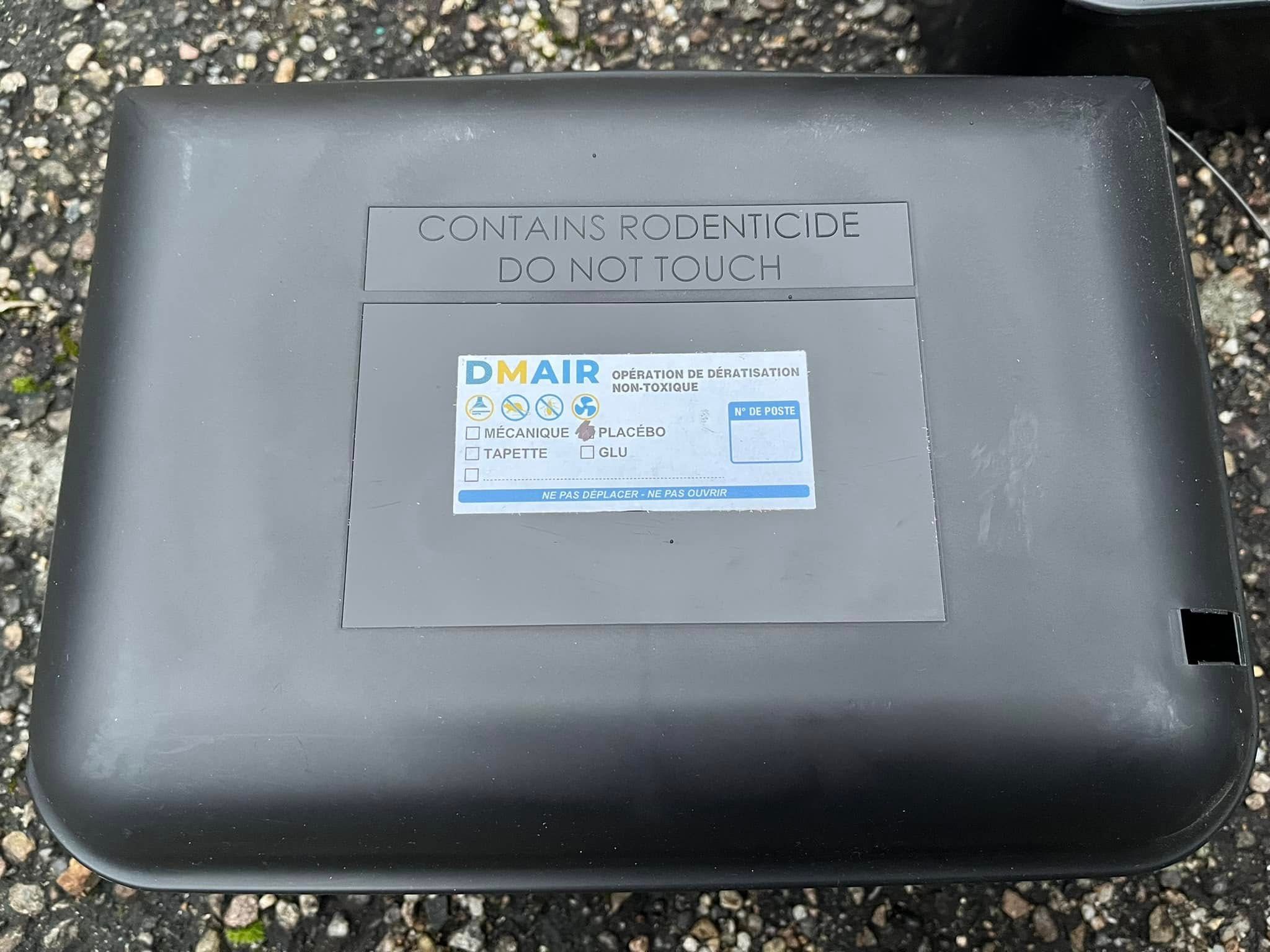 Une boîte à appât pour rongeurs de forme rectangulaire noire.