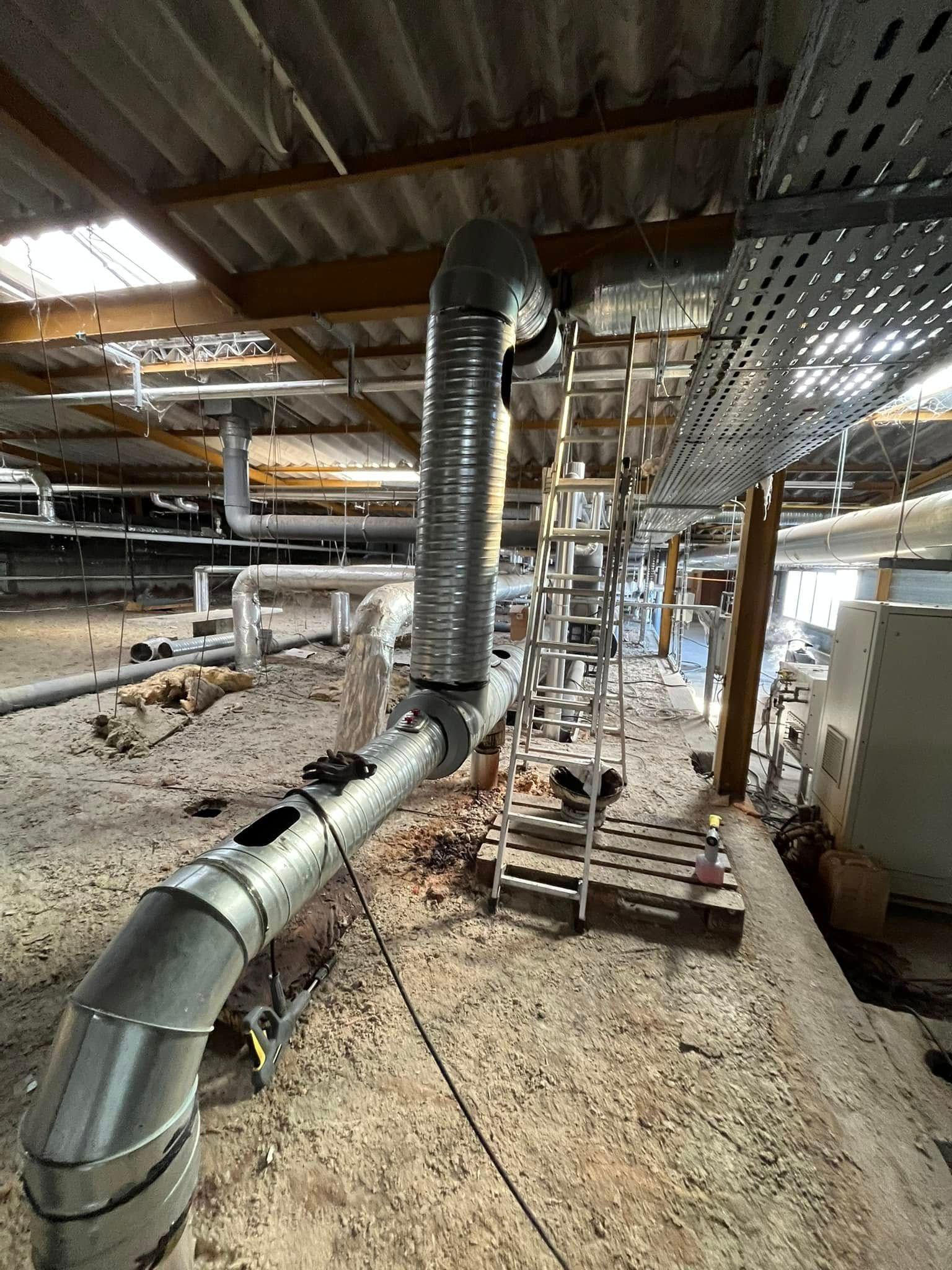 Un système de ventilation industriel en cours de nettoyage par DMAIR.