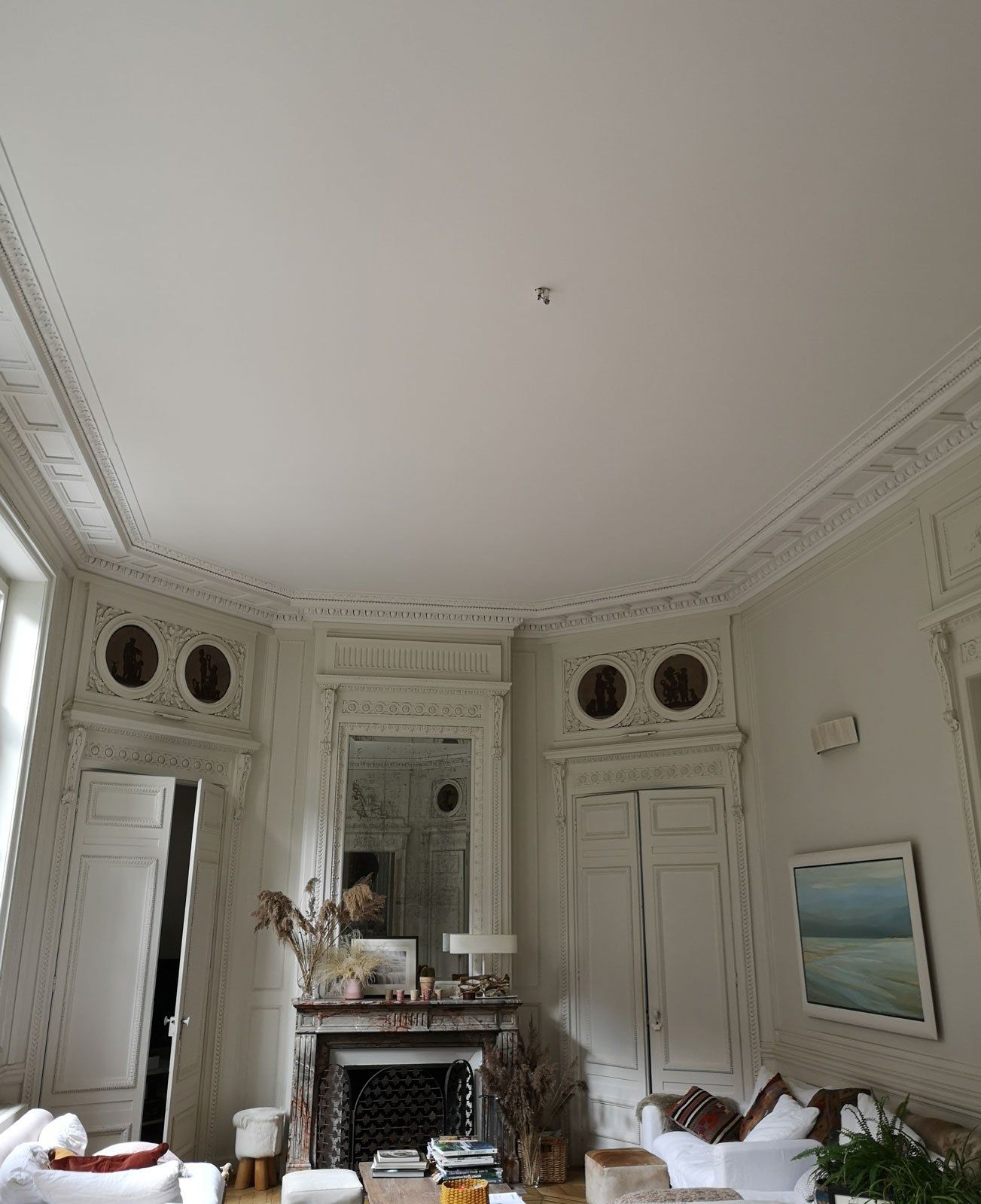 Pièce avec grande hauteur sous plafond et beaucoup de plâtrerie au plafond