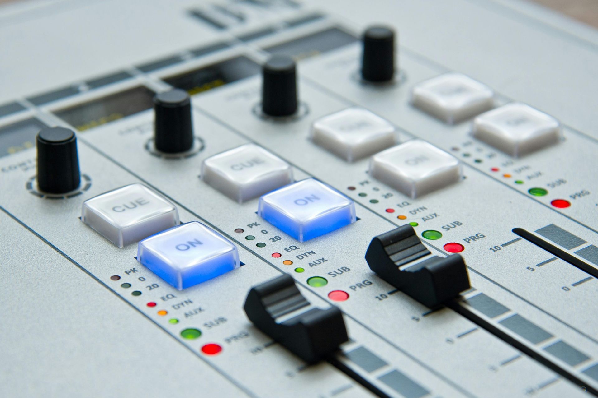 Primer plano de una mesa de mezclas de sonido con perillas, botones