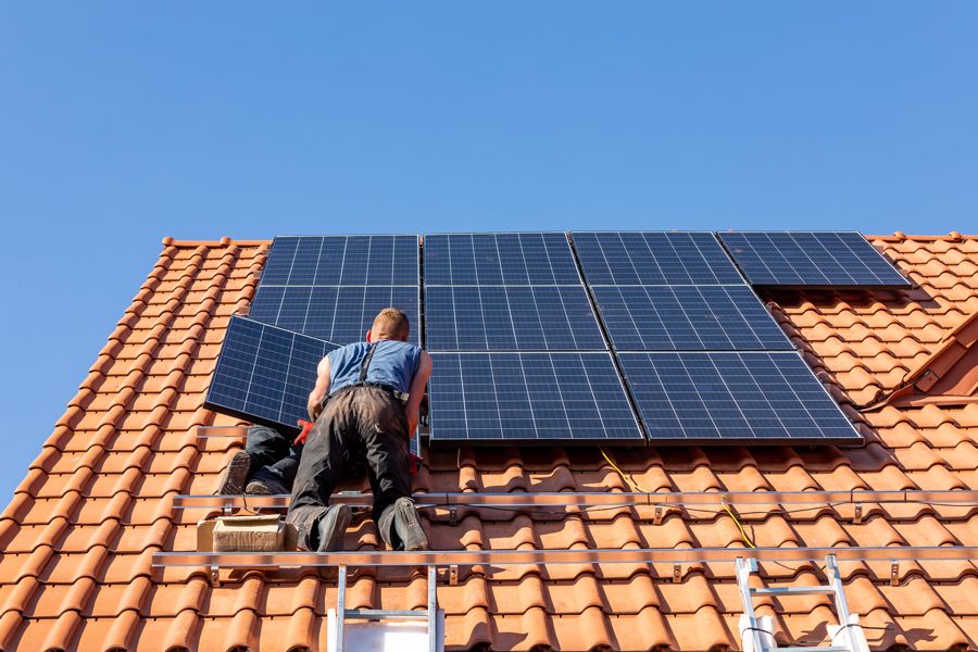 Professionnel posant des panneaux photovoltaïques sur une toiture