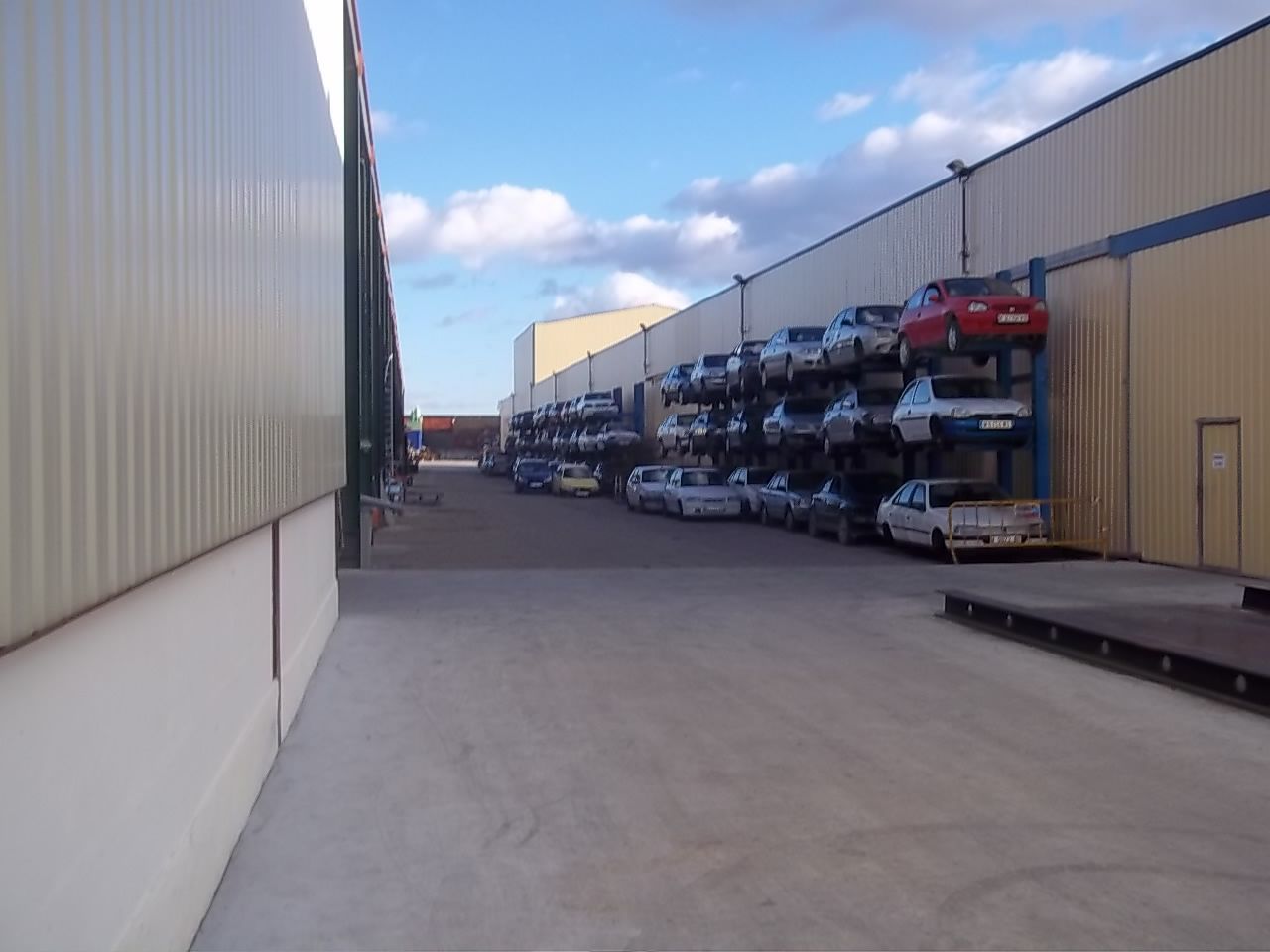 Hay muchos coches aparcados delante de un edificio.