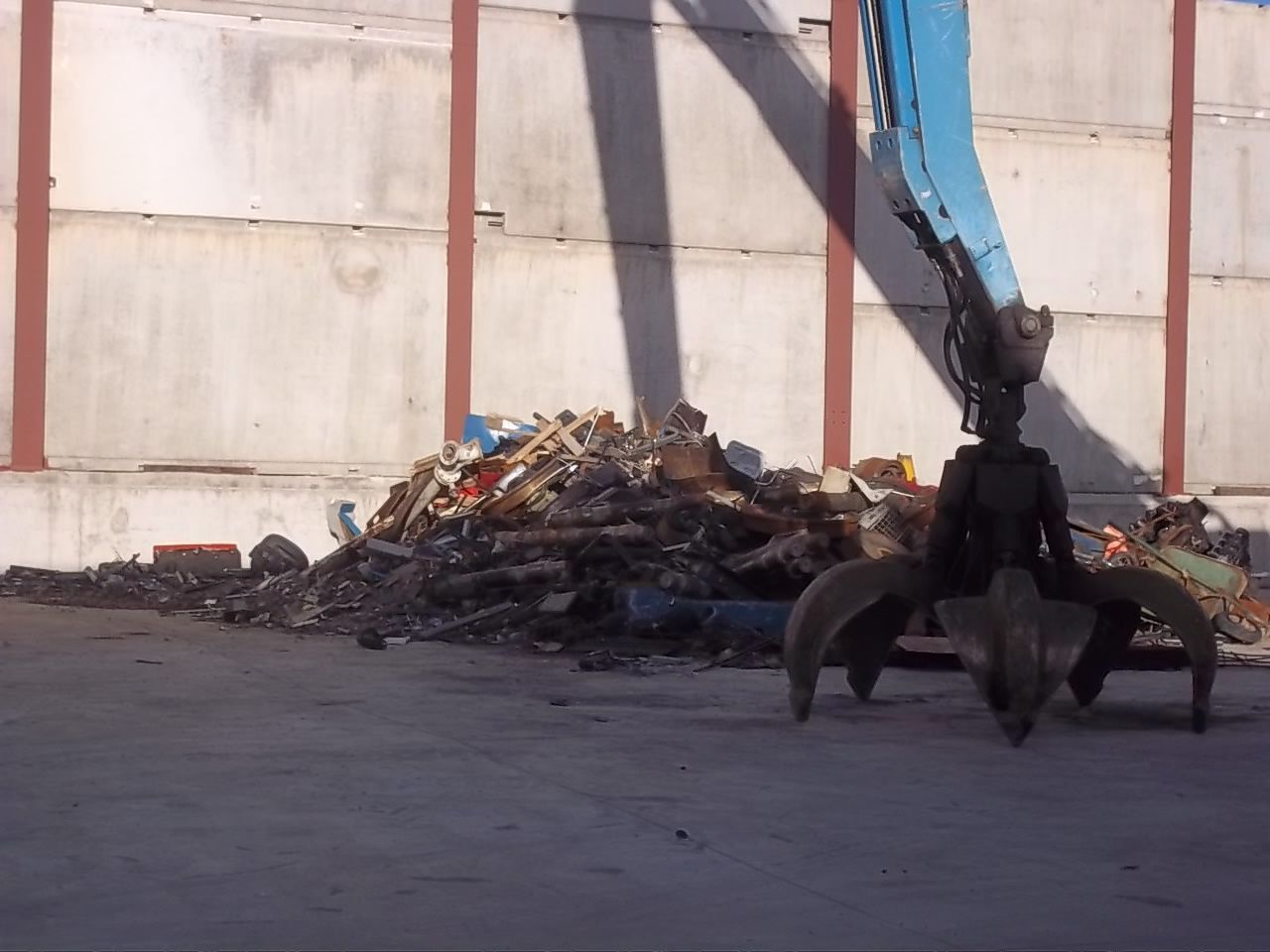 Una gran pila de chatarra está siendo levantada por una grúa