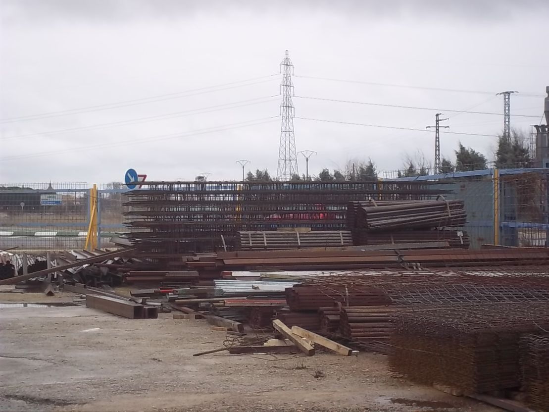 Un almacén lleno de muchas piezas de metal en un día nublado.
