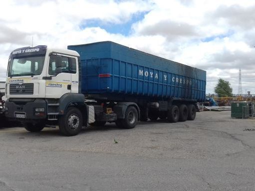 Un camión azul y blanco está estacionado en un estacionamiento.