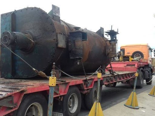 Un gran objeto metálico se encuentra en la parte trasera de un camión.