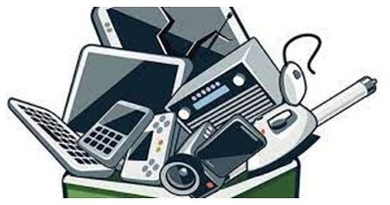 Una pila de desechos electrónicos se encuentra encima de un contenedor verde.