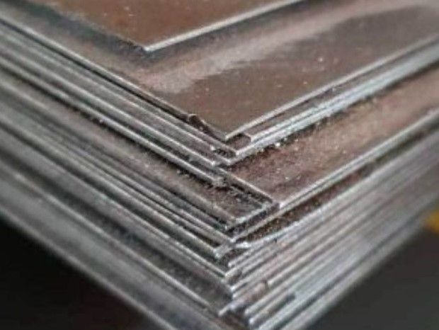 Una pila de láminas de metal colocadas una encima de otra sobre una mesa.