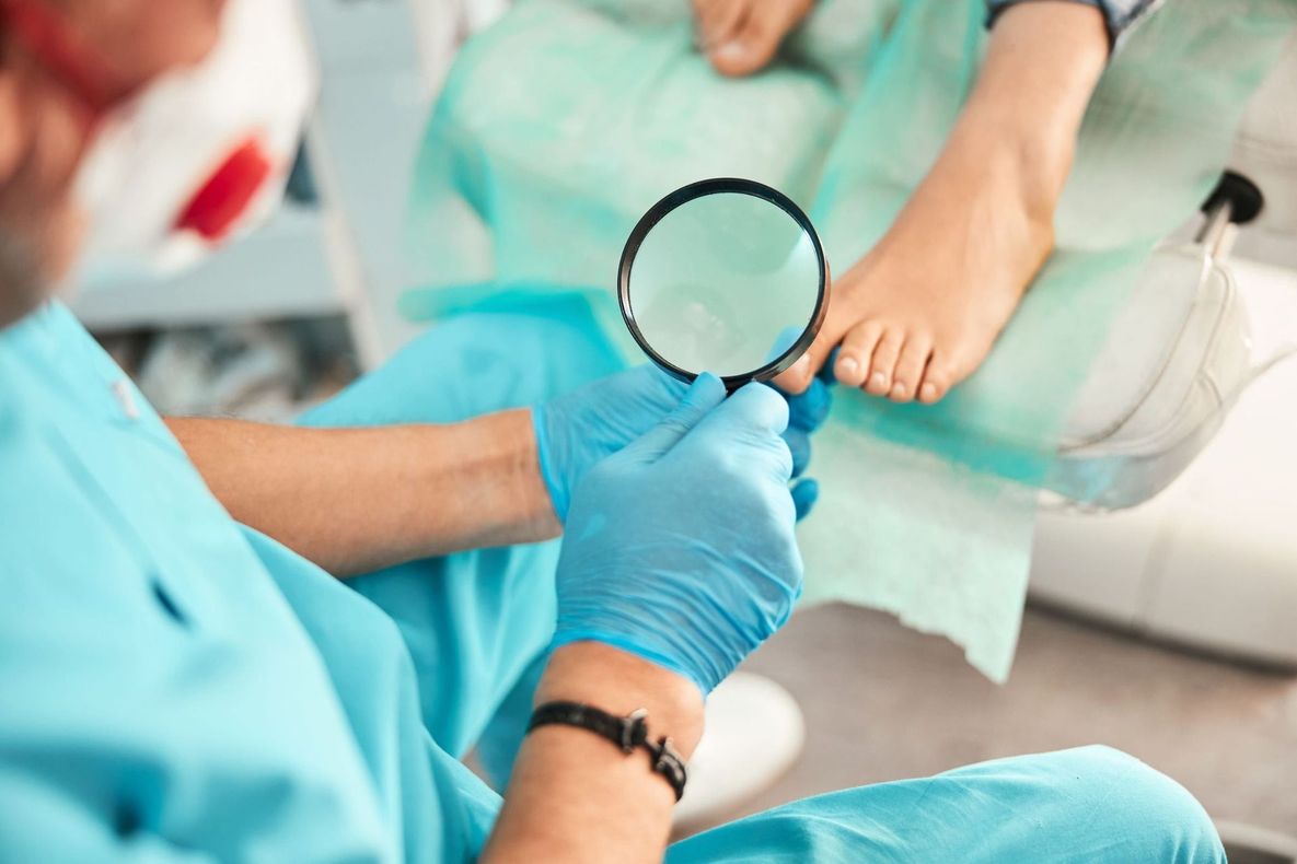 Personal médico con uniformes azules examina a un paciente con una lupa en un entorno clínico.