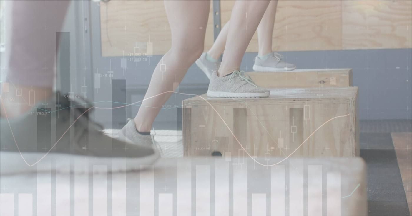 Personas con zapatillas deportivas subiéndose a cajas de madera en un estudio luminoso.