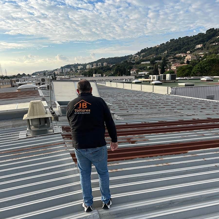 artisan vu de dos sur toiture en tole