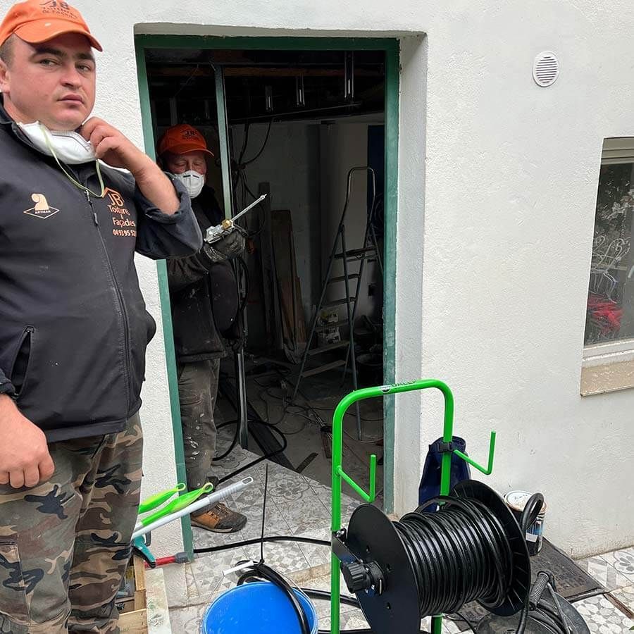 ouvriers en chantier avec enrouleur électrique au premier plan