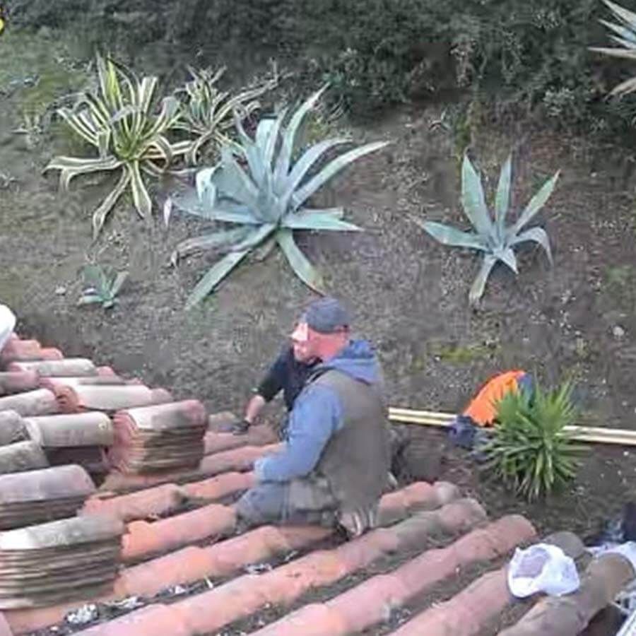 deux ouvriers remplaçant des tuiles sur toiture en ardoise