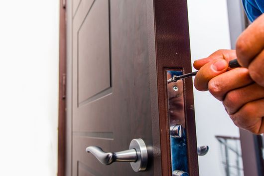 Main insérant une clé dans la serrure d'une porte.