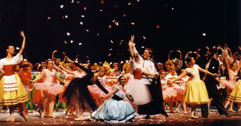 Un grupo de personas está bailando en un escenario con confeti cayendo del cielo.