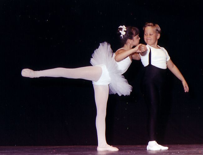 Un niño y una niña bailan juntos en un escenario.