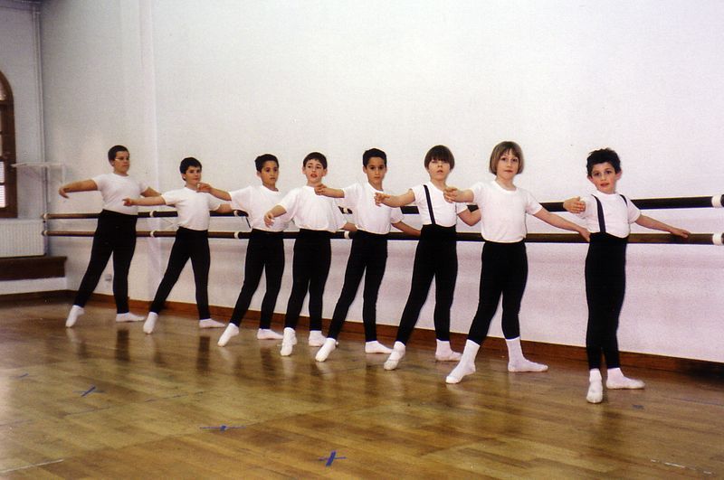 Un grupo de chicos jóvenes están practicando ballet en un estudio de danza.