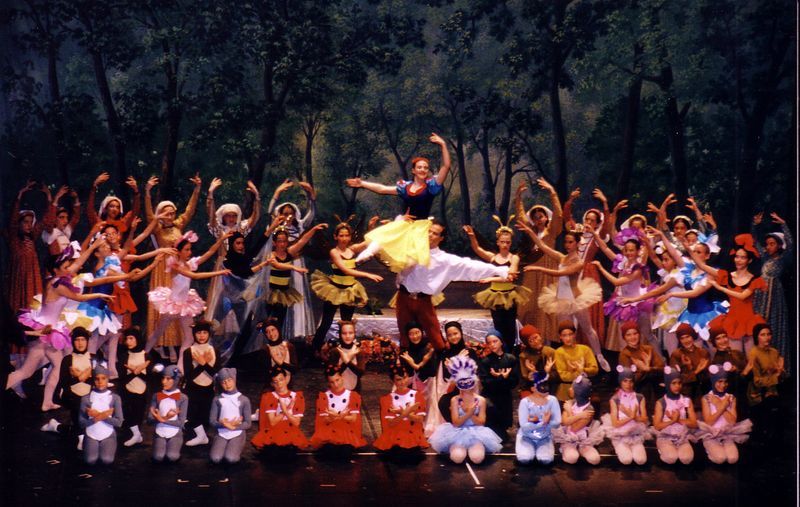 Un grupo de bailarinas posan para una foto en un escenario.