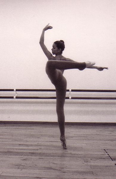 Una fotografía en blanco y negro de una bailarina haciendo un split.