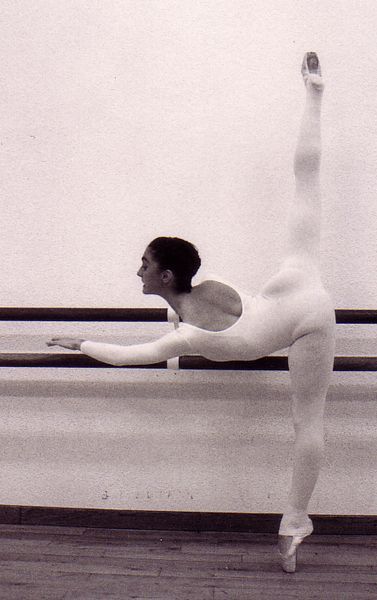 Una fotografía en blanco y negro de una bailarina haciendo un split.