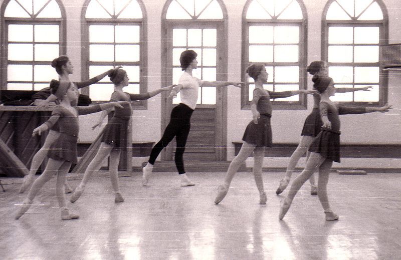 Un grupo de chicas jóvenes están practicando ballet en un estudio de danza.