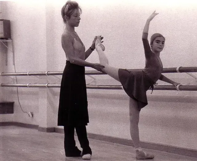 Una mujer ayuda a una joven bailarina a realizar un estiramiento de ballet cerca de la barra. Ambas escenas se desarrollan en un estudio.