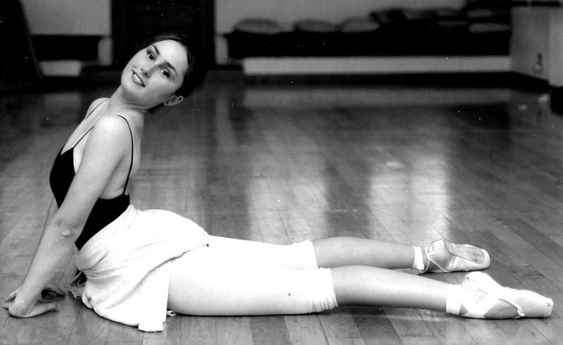 Una fotografía en blanco y negro de una bailarina tumbada en el suelo.