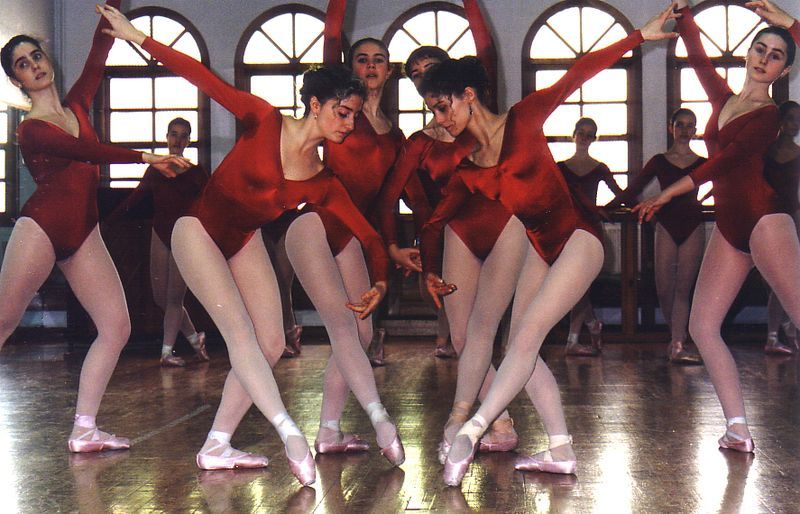 Un grupo de mujeres con leotardos rojos y zapatos rosas están bailando