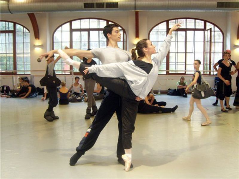 Un hombre sostiene a una mujer en sus brazos en un estudio de baile.