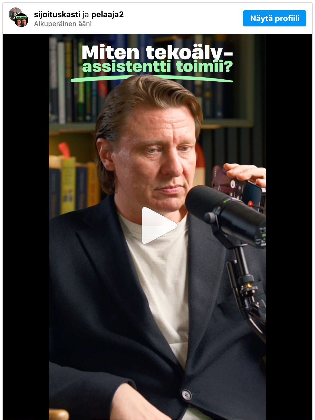 Mies puhuu mikrofoniin kirjahyllyjen täyttämässä huoneessa. Vihreä teksti kysyy